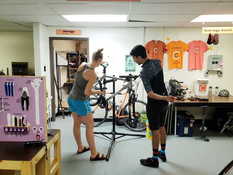 two people in workshop fixing bike